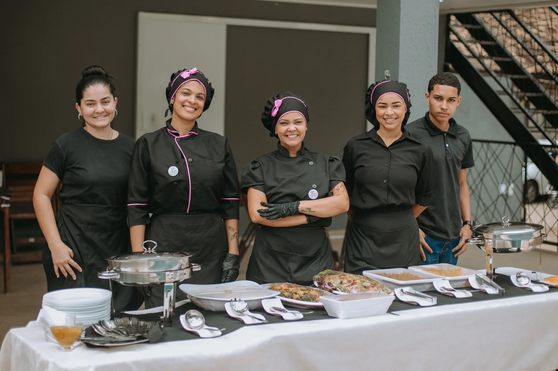 Equipe profissional com mesa de buffet montada para evento.